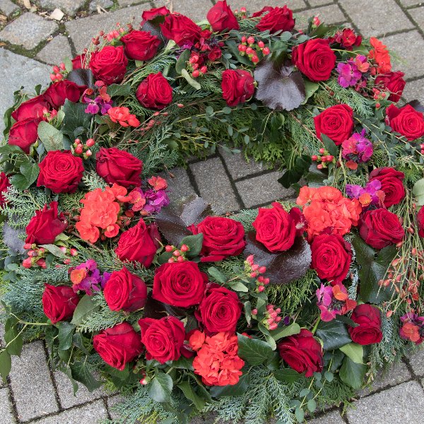 Trauerkranz rundgesteckt mit roten Rosen und Beiwerk Bild 1