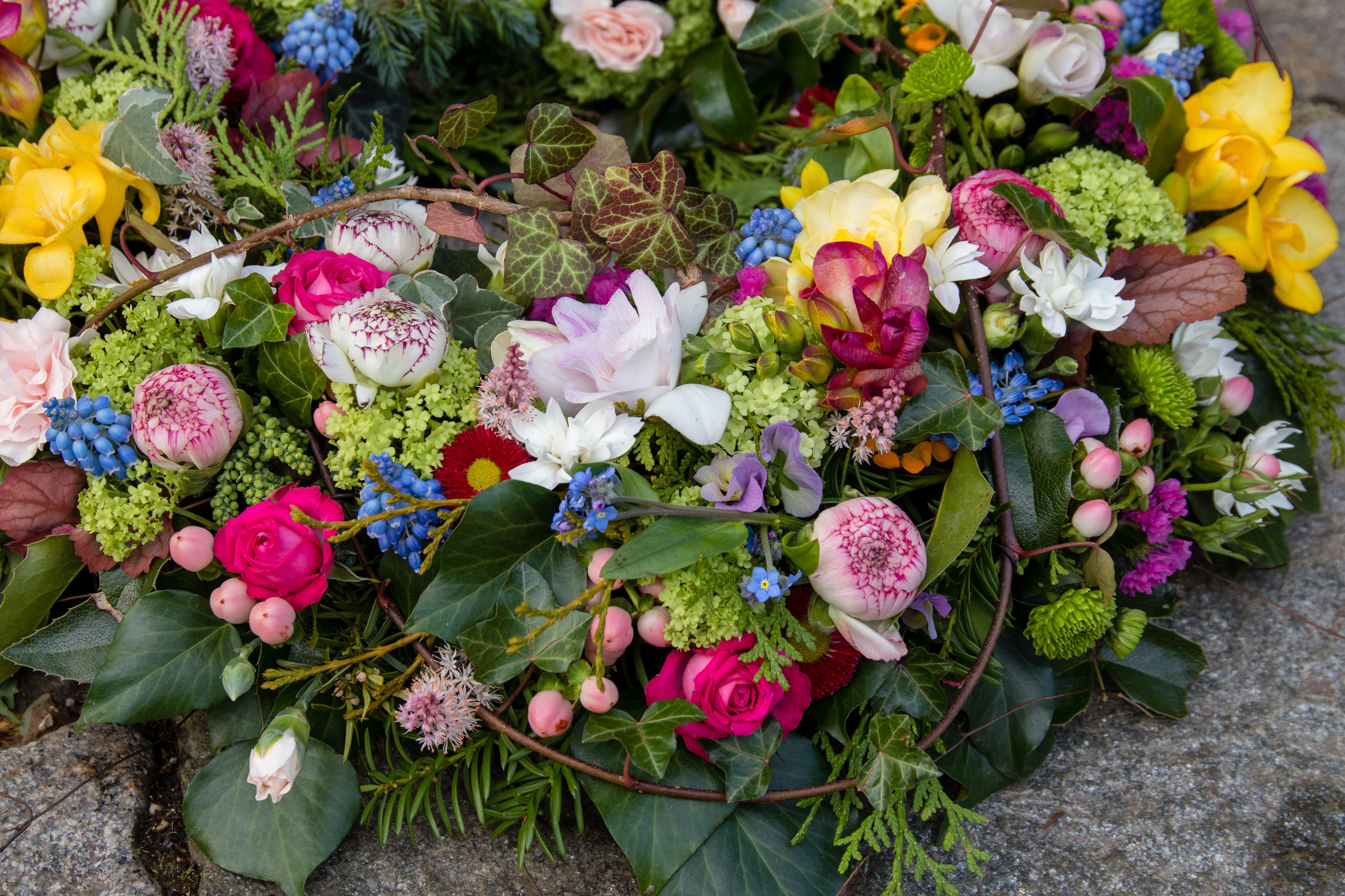 Trauerkranz rundgesteckt mit Frühlingsblüten, Rosen und Nelken Bild 2