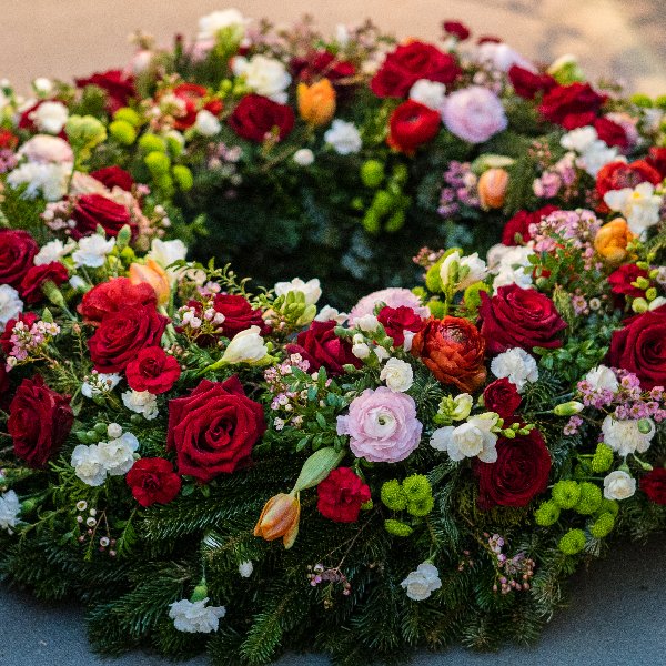 Trauerkranz rundgesteckt mit Rosen und Nelken Bild 1