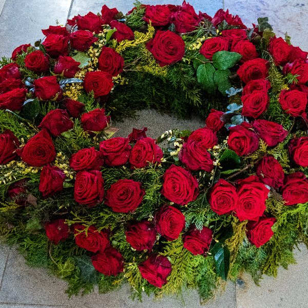 Trauerkranz rundgesteckt mit roten Rosen Bild 1